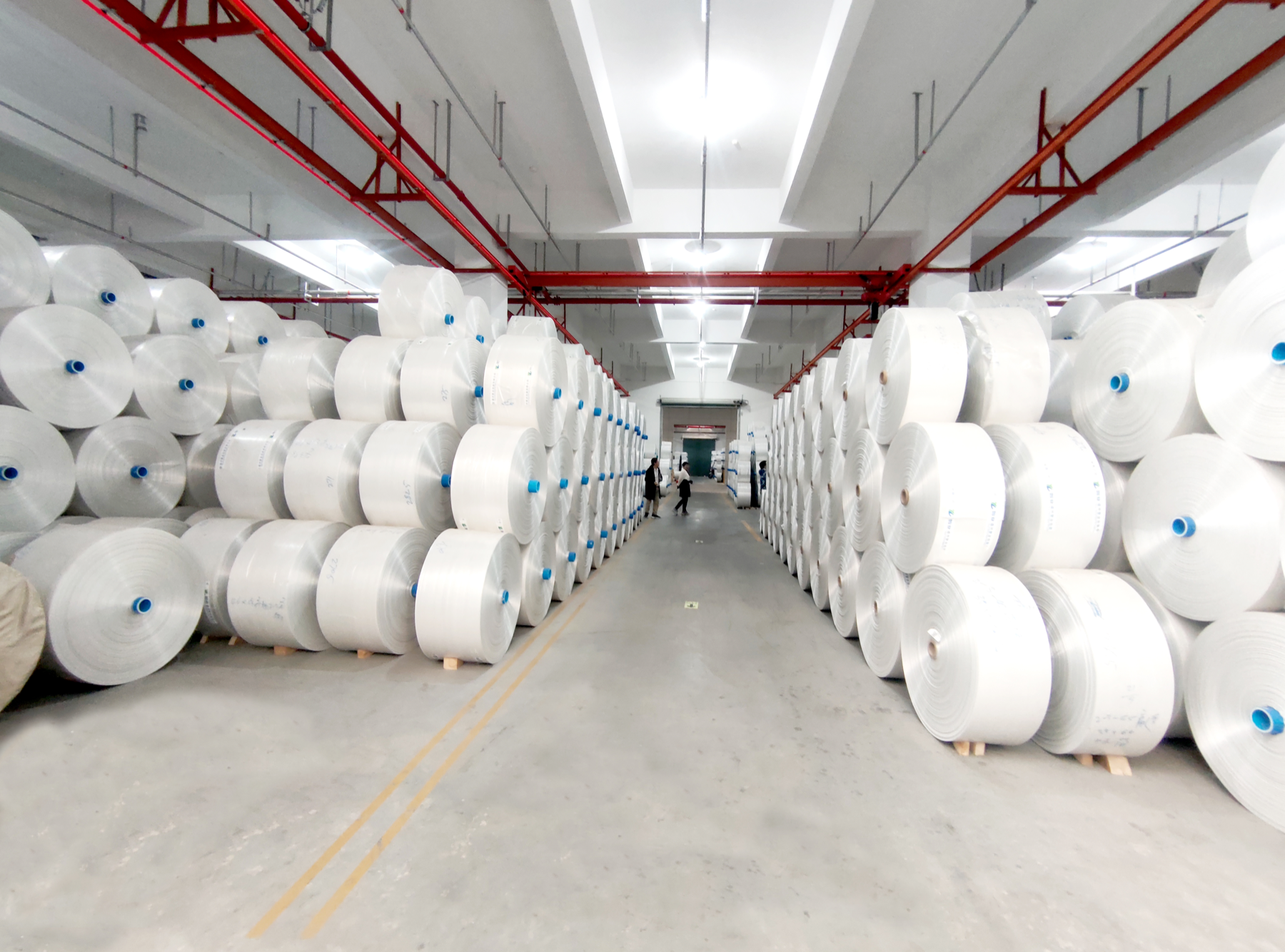 Rolls of packaging material stored at a partner factory